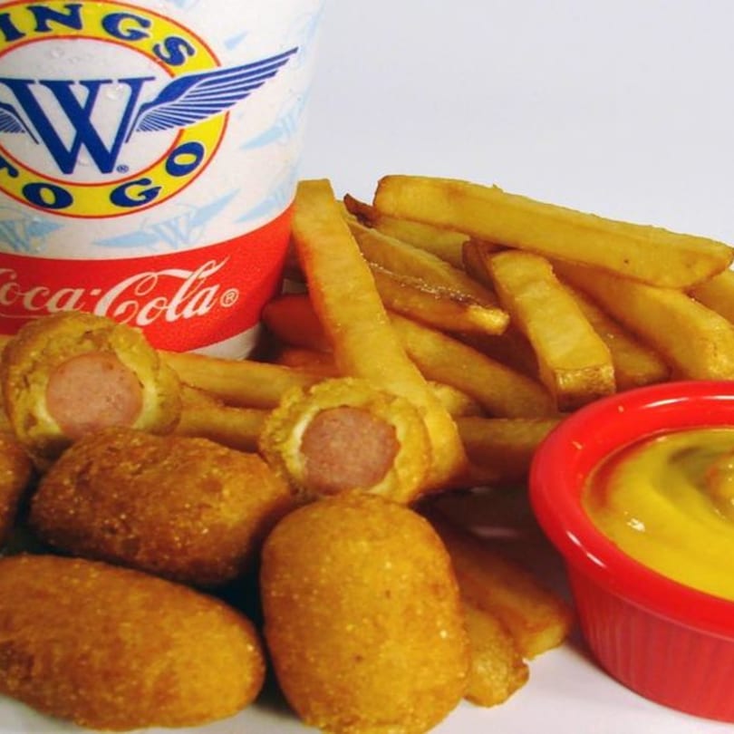 Wings to Go corn dogs, french fries, mustard, and a Coca-Cola cup.